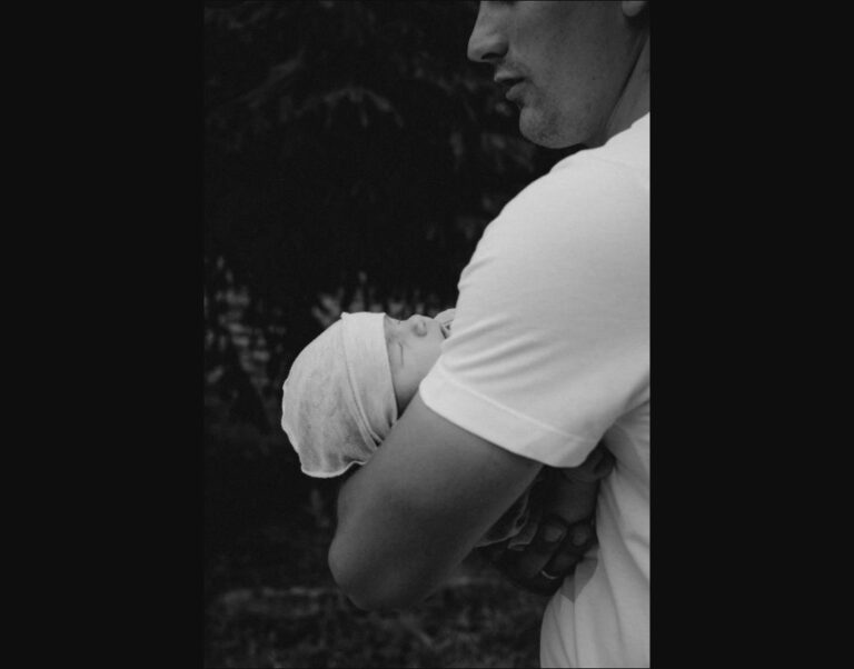 A father with his newborn, reflecting a first Father's Day milestone.