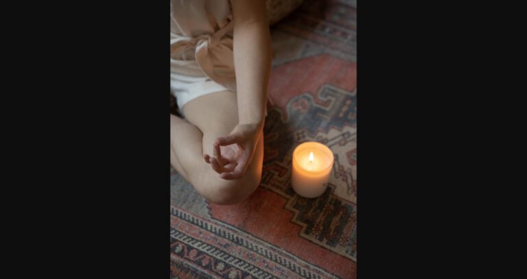A set of mindfulness ritual objects — cushion, candle, and journal — arranged thoughtfully.