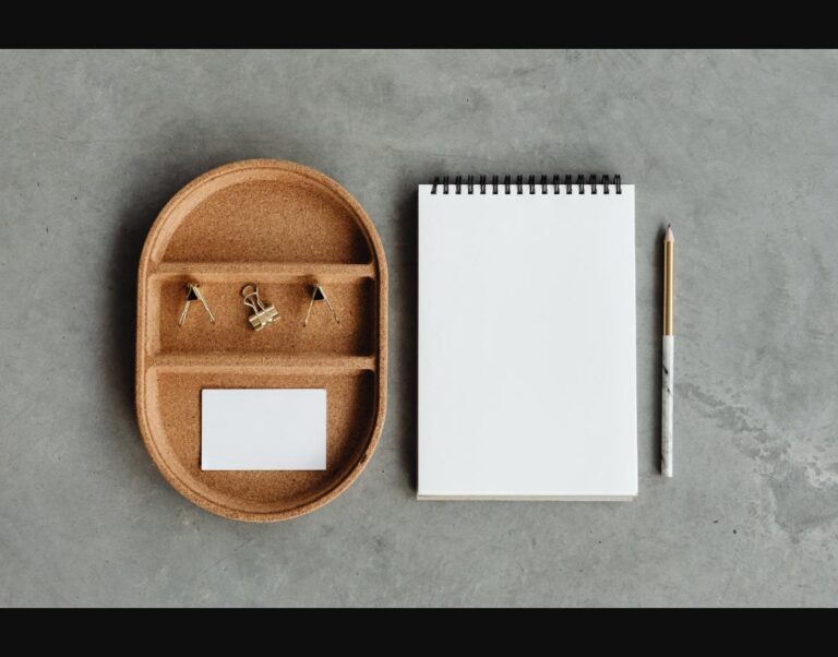 A minimalist, organized desk setup with a task lamp and monitor riser.