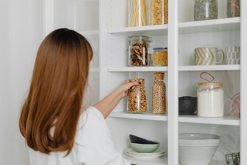 minimalist micro pantry setup with glass bamboo jars and woven baskets