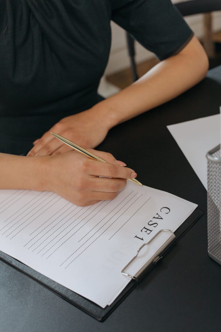 Stack of documents and a laptop on a desk, representing reviewing long reports