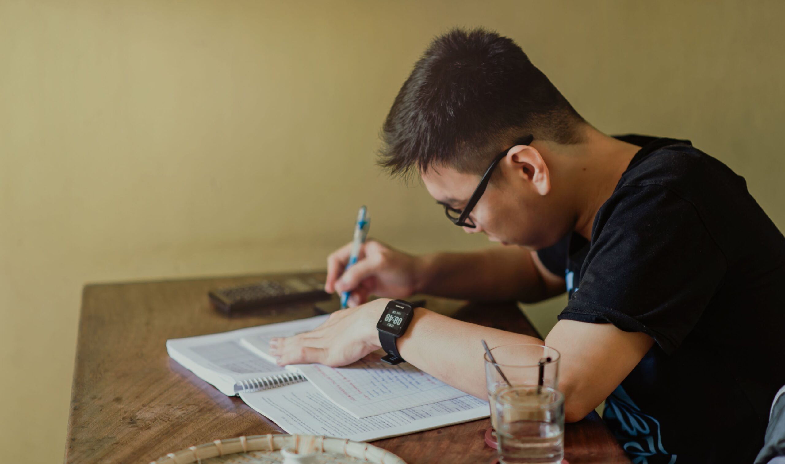 Student studying with a laptop and notebook, using AI tools to help with schoolwork